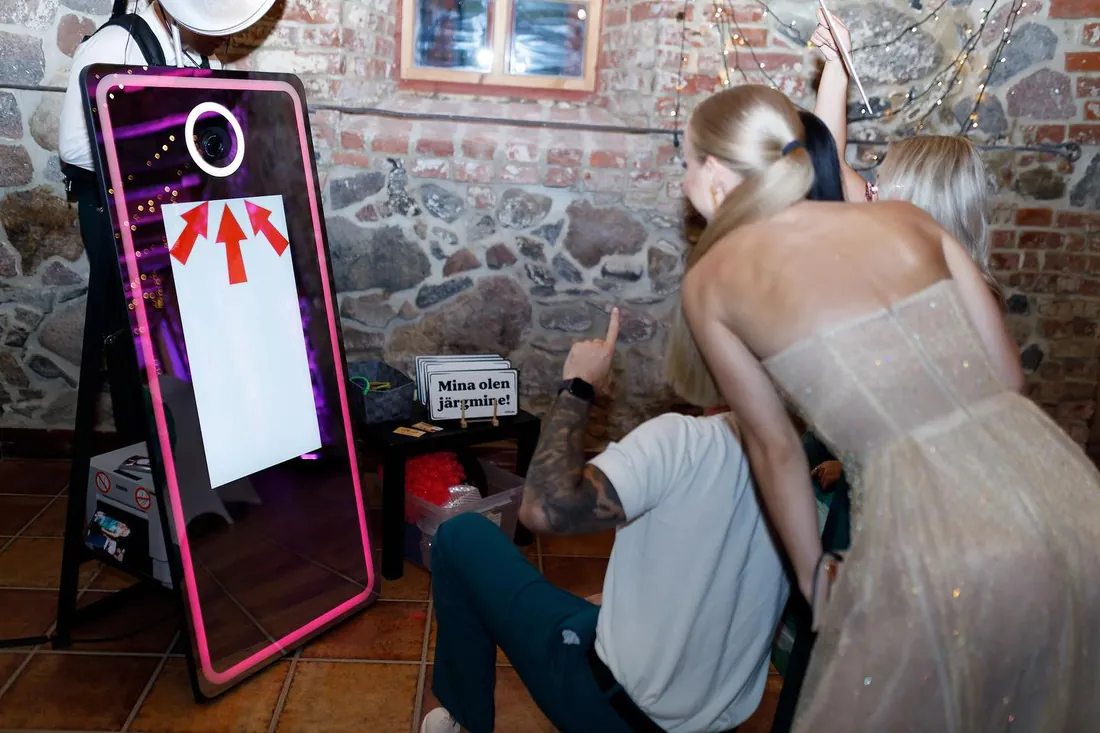 Külalised fotopeegli ees kiviseinaga saalis
